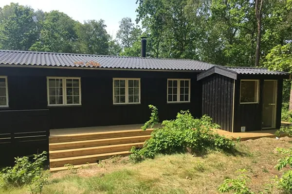 Sommerhus med sort facade og nye vinduer